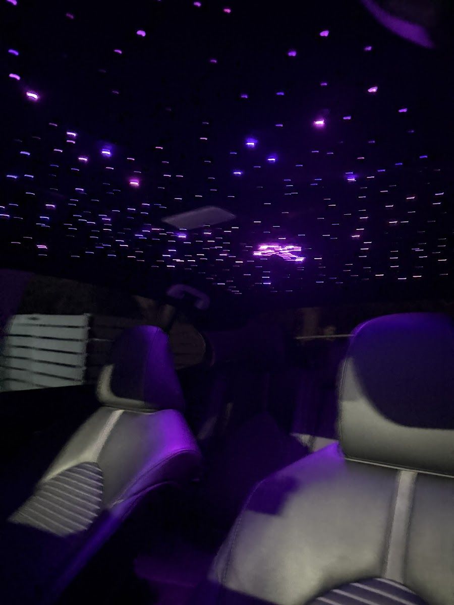 Dense fibre-optic starfield across a car ceiling in violet