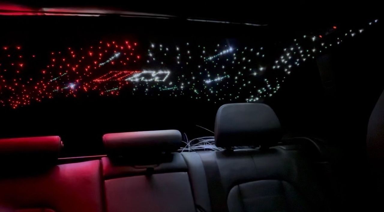 Red fiber-optic starlight headliner with a BMW F30 motif
